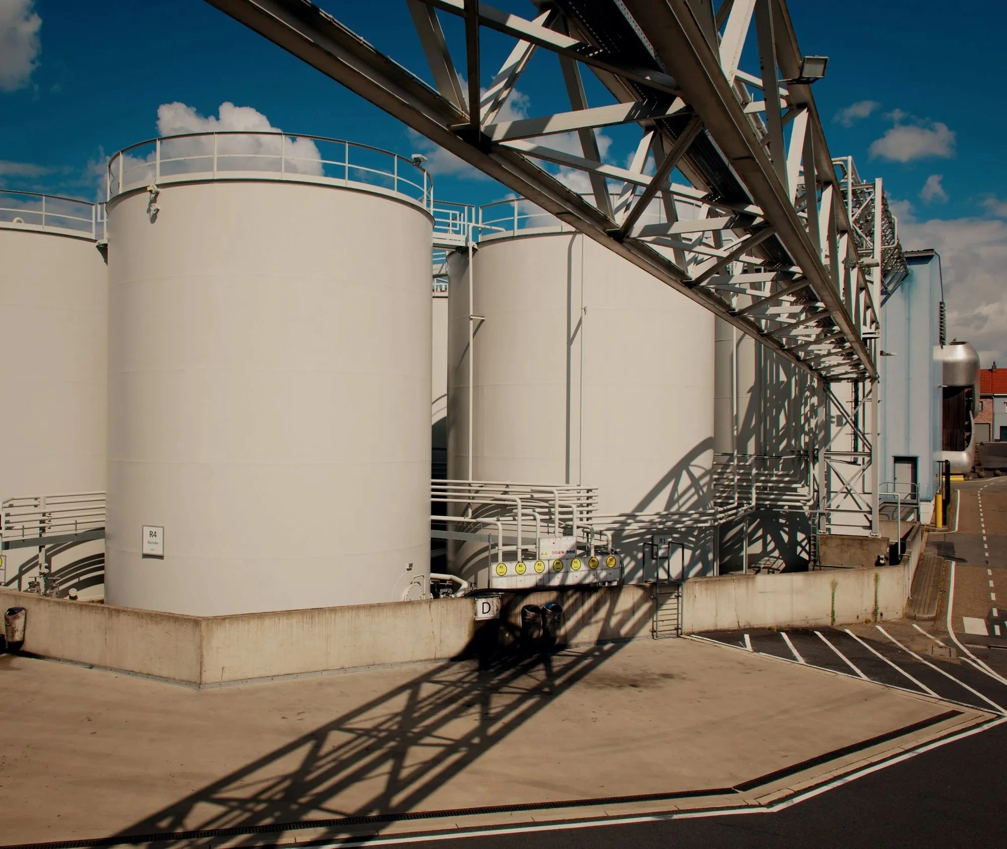 Industrial storage tanks under a blue sky